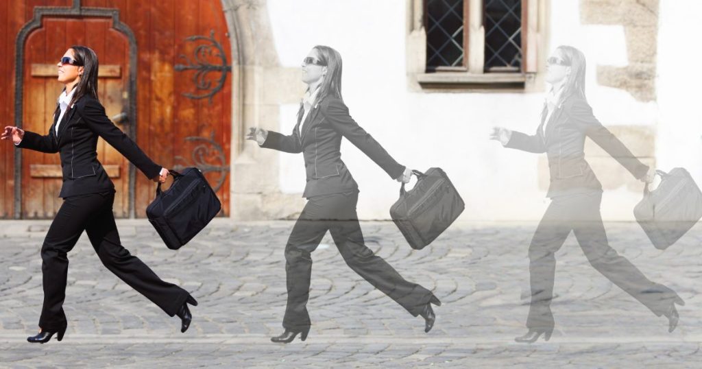 A businesswoman in a suit and sunglasses walks confidently with a briefcase, followed by faded shadow versions of herself—illustrating the concept of an "IT Shadow" and unseen or duplicative activity in the business world.