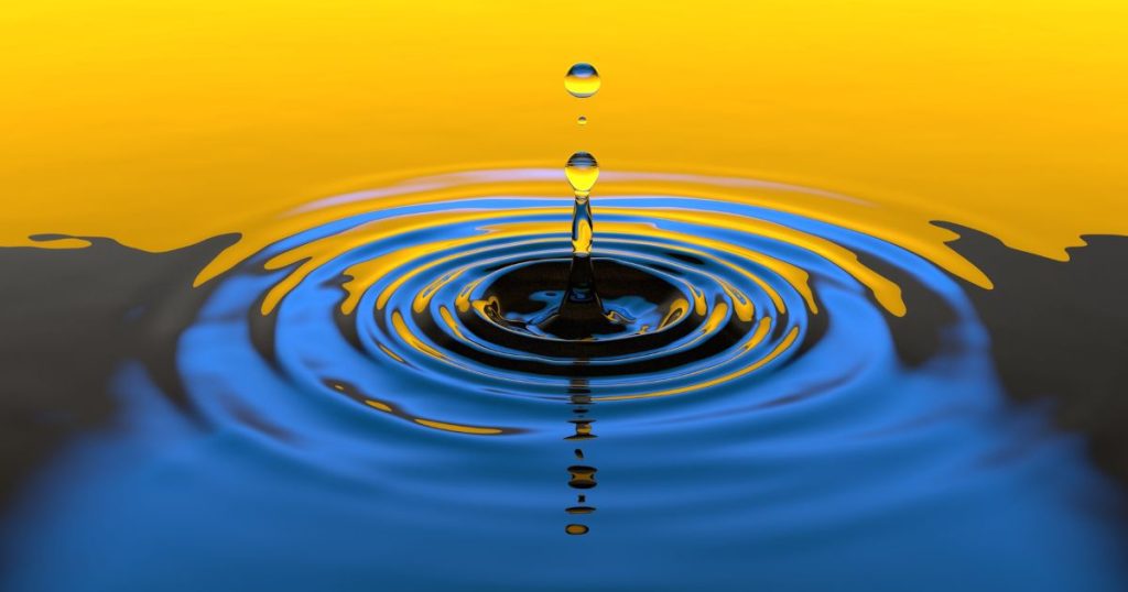 A close-up of water droplets creating ripples in a pool, with a yellow and blue gradient sky—symbolizing the ripple effect of federal tax law changes on real estate.